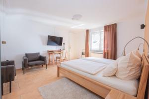 ein Schlafzimmer mit einem Bett, einem Stuhl und einem Tisch in der Unterkunft Märchenwald Altenberg B&B Hotel in Odenthal