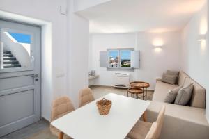 a white dining room with a white table and chairs at Hill Suites in Fira