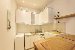 a kitchen with white cabinets and a sink at Apartments Villa Devana 2 in Opatija