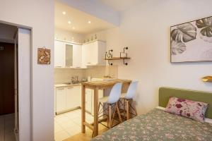 a bedroom with a bed and a kitchen with a table at Apartments Villa Devana 2 in Opatija