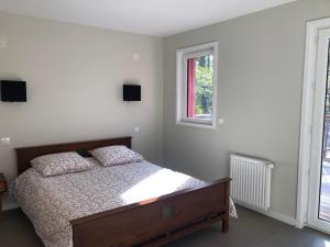 a bedroom with a bed and two windows at Villa Orchidee in Lacanau-Océan