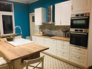 a kitchen with white cabinets and a sink at Le nichoir d’hirondelles in Tintigny