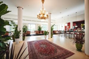 eine Lobby mit einem Teppich auf dem Boden und einem Kronleuchter in der Unterkunft Hotel Weitzer Graz - Centre of Graz in Graz
