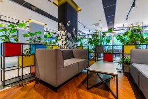 sala de estar con plantas, sofá y mesa en Hotel Wyspiański, en Cracovia