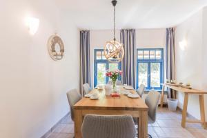 a dining room with a wooden table and chairs at Ferienhaussiedlung Strandperlen Sanddornhof 6a (Typ VII) in Wustrow