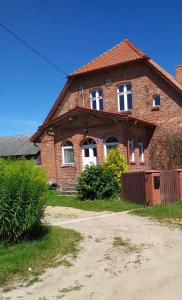 Casa de ladrillo con puertas y ventanas blancas en Wczasy na Kaszubach en Górki