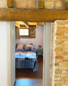ein Schlafzimmer mit einem Bett und einer Ziegelwand in der Unterkunft El celler de Cal Garriga in Capafons