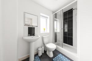 a white bathroom with a toilet and a sink at Royal House Wolverhampton - Perfect for Contractors & Large Groups in Wolverhampton +7 photos