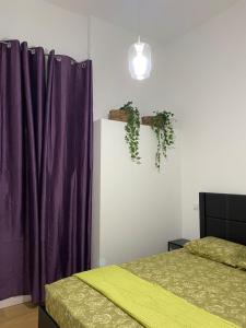 1 dormitorio con 2 camas y cortinas moradas en Aluche Aparment A, en Madrid
