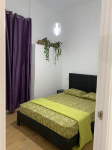 Un dormitorio con una cama con una manta amarilla. en Aluche Aparment A, en Madrid