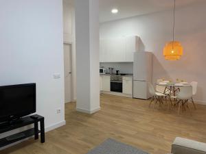 a living room with a kitchen and a table with chairs at Aluche Aparment A in Madrid