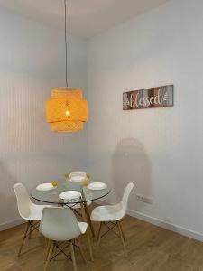 a dining room with a table and white chairs at Aluche Aparment A in Madrid