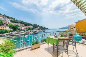 a balcony with a table and chairs and a view of the water at Room Mariza in Rabac