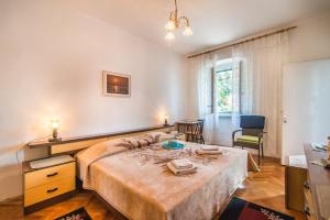 a bedroom with a large bed and a chair at Room Sandra in Rabac