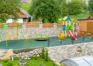a playground in a stone wall with a play yard at GORHouse Hotel in Yaremche