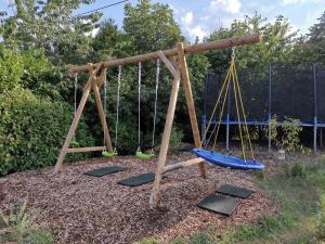 a swing set with two swings and three rocks at Eifelferienkurth in Buir