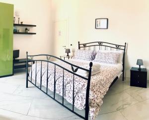 1 dormitorio con cama negra y colcha de flores en U Palazzieddu Rooms, en Pachino