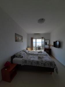 ein Schlafzimmer mit einem Bett und einem großen Fenster in der Unterkunft Villa Kubo in Lovran