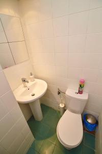 a bathroom with a white toilet and a sink at Regem Apartments Waryńskiego in Warsaw