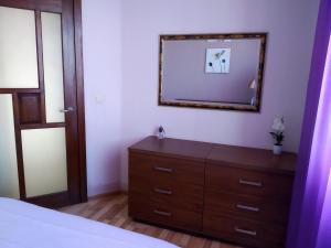 - une chambre avec une commode et un miroir mural dans l'établissement Baltijos 12b Apartamentai, à Klaipėda
