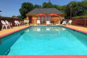 a swimming pool with chairs and a gazebo at Baymont by Wyndham Selma in Selma