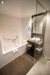 a bathroom with a shower, sink, and mirror at Van der Valk Hotel Hoorn in Hoorn
