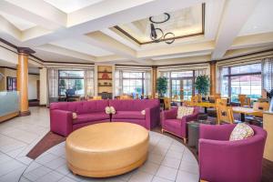 a waiting room with purple couches and tables at La Quinta by Wyndham Atlanta Ballpark/Galleria in Atlanta