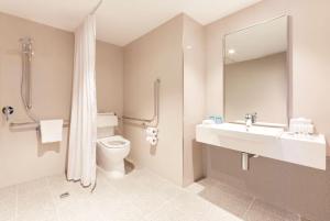 
a bathroom with a toilet, sink, tub and shower at Holiday Inn Express Adelaide City Centre, an IHG Hotel in Adelaide
