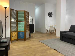 uma sala de estar com um sofá e uma mesa em Aluche Aparment B em Madrid