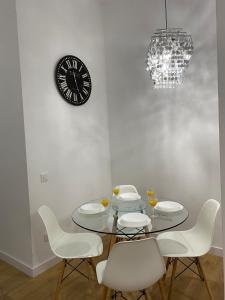 comedor con mesa, sillas y reloj en Aluche Aparment B en Madrid