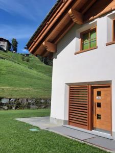 a house with a wooden garage door at Chalet Taulei in Valdidentro