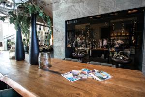 een houten tafel in een restaurant met een bar bij Van der Valk Hotel Hoorn in Hoorn