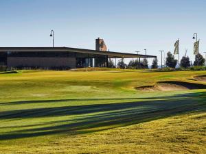 a golf course with a green and a building at The Sebel Yarrawonga Silverwoods in Yarrawonga