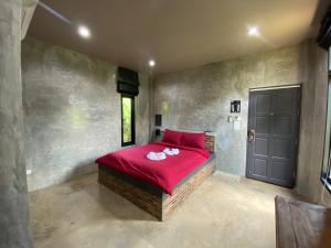 Watthana NakhonThe Loft House Sakaeo的一间卧室设有红色的床和黑色的门
