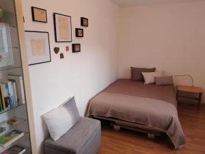1 dormitorio pequeño con 1 cama y 1 silla en Konditor B & B, en Frenkendorf