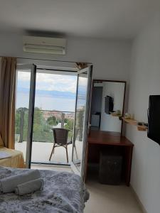 a bedroom with a bed and a view of a balcony at Villa Kubo in Lovran