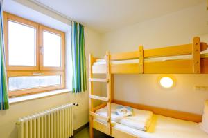 ヴンジーデルにあるJugendherberge Wunsiedelのベッドルーム1室(二段ベッド2台、窓付)が備わります。