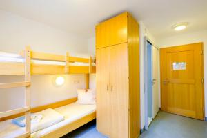 a dorm room with bunk beds and a closet at Jugendherberge Wunsiedel in Wunsiedel