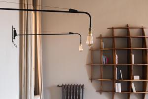 a black lamp hanging from a wall with a book shelf at Cà Bellavista in Venice