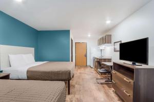 um quarto de hotel com duas camas e uma televisão de ecrã plano em WoodSpring Suites | North Charleston Airport I-526 em Charleston