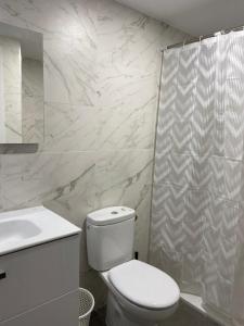 a white bathroom with a toilet and a shower at Aluche Aparment C in Madrid