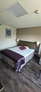Un pat sau paturi într-o cameră la First Hotel Royal