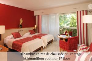 a hotel room with two beds and a window at The Originals Boutique, Hôtel Les Strélitzias in Juan-les-Pins