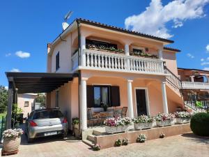 a house with a balcony and a car parked in front at Apartment Katarina in Vodnjan