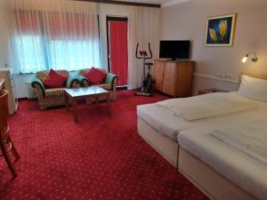 ein Hotelzimmer mit 2 Betten und einem Sofa in der Unterkunft Hotel Faller in Breitnau