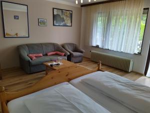 a living room with a bed and a couch at Hotel Faller in Breitnau