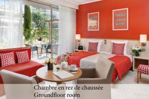 Habitación de hotel con cama, mesa y sillas en The Originals Boutique, Hôtel Les Strélitzias, en Juan-les-Pins