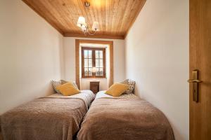 2 camas en una esquina de una habitación con ventana en Casa Fonte da Mina, en Fundão