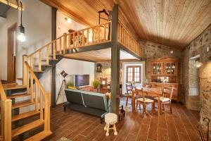 a living room with a spiral staircase and a dining room at Casa Fonte da Mina in Fund�o