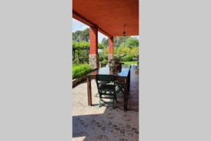 een patio met een tafel en stoelen onder een dak bij CASA RURAL LAS TRAVIESAS 2 in Candeleda